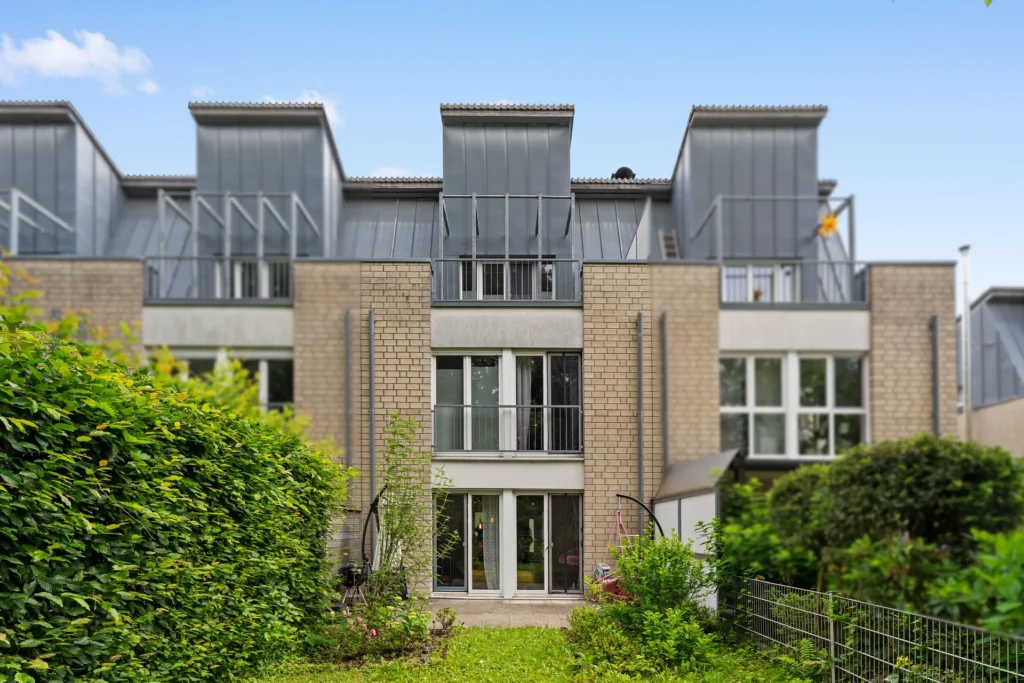 Rückansicht des modernen Reihenhauses mit Garten und Terrasse