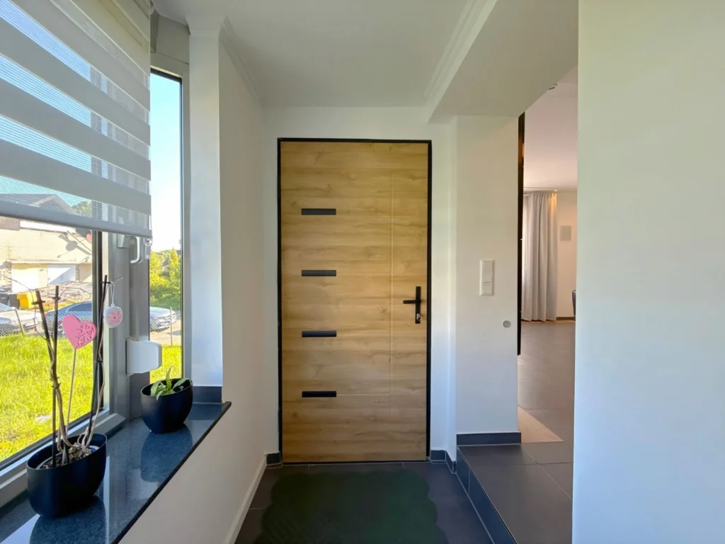 Einladender Eingangsbereich mit moderner Holz-Haustür und Tageslicht