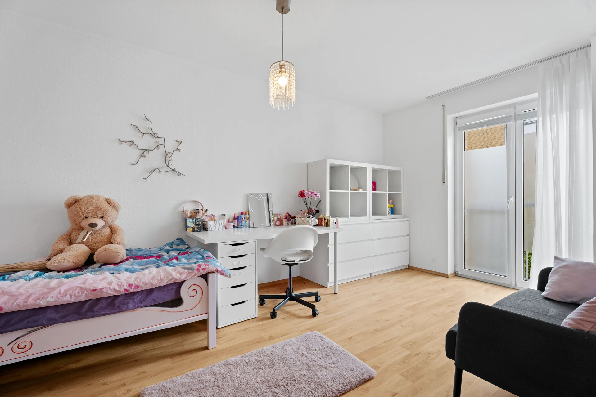 Geräumiges Kinderzimmer mit Schreibtisch und Balkonzugang