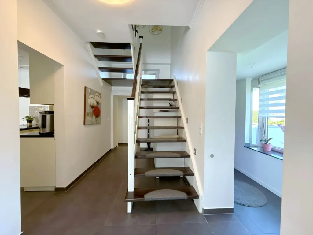 Moderner Eingangsbereich mit offener Holztreppe
