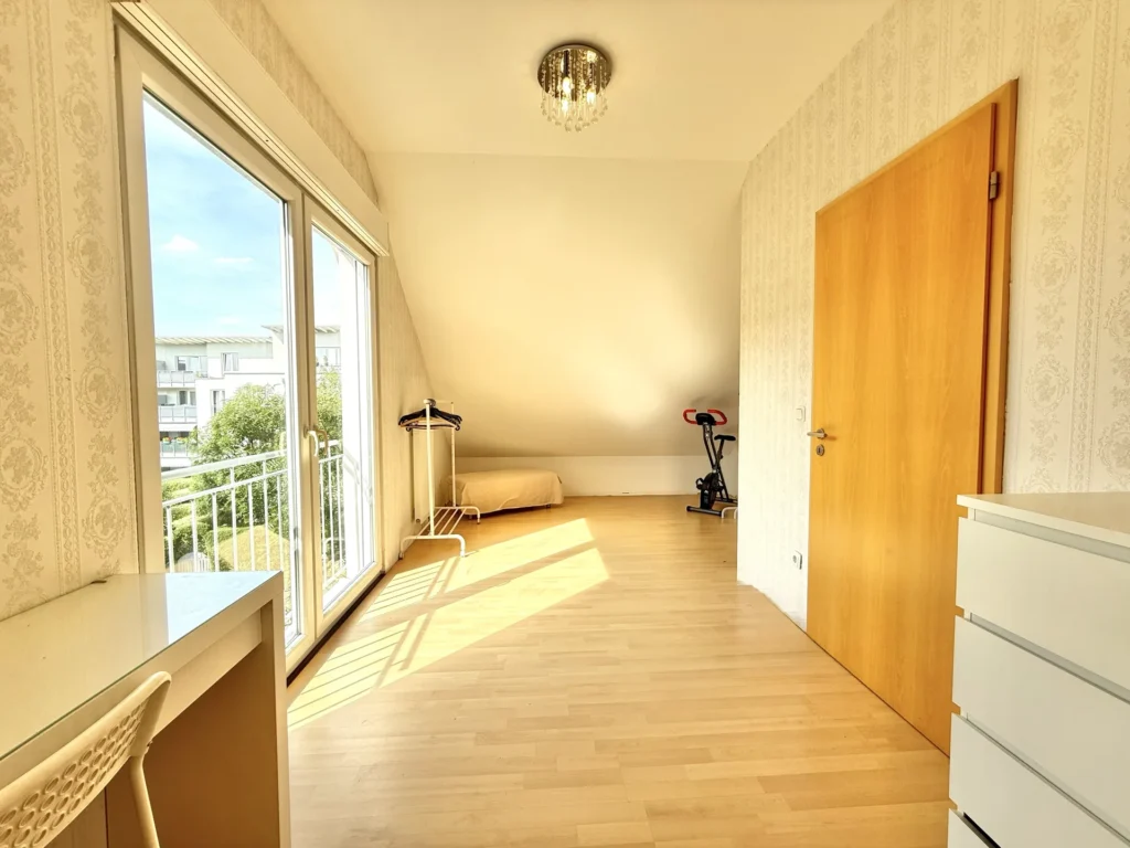 Helles Kinderzimmer mit großer Fensterfront und Zugang zum Balkon