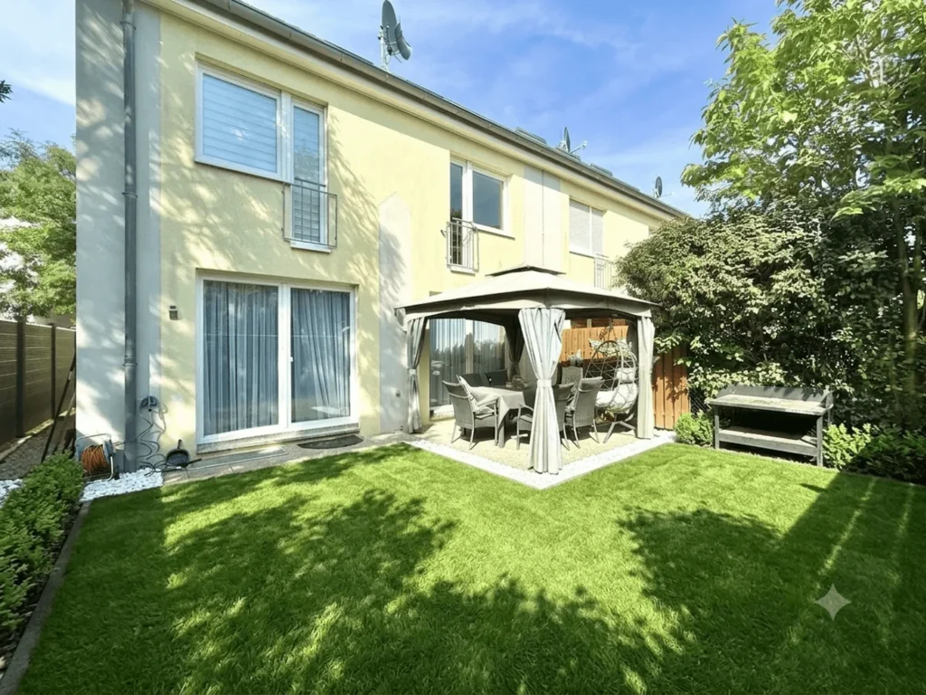 Rückansicht des Wohnhauses mit Garten und überdachtem Terrassenbereich