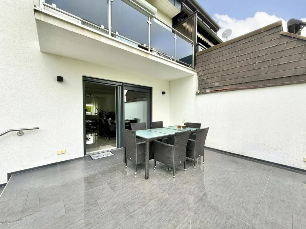 Überdachte Terrasse mit Sitzgruppe und direktem Zugang zum Garten