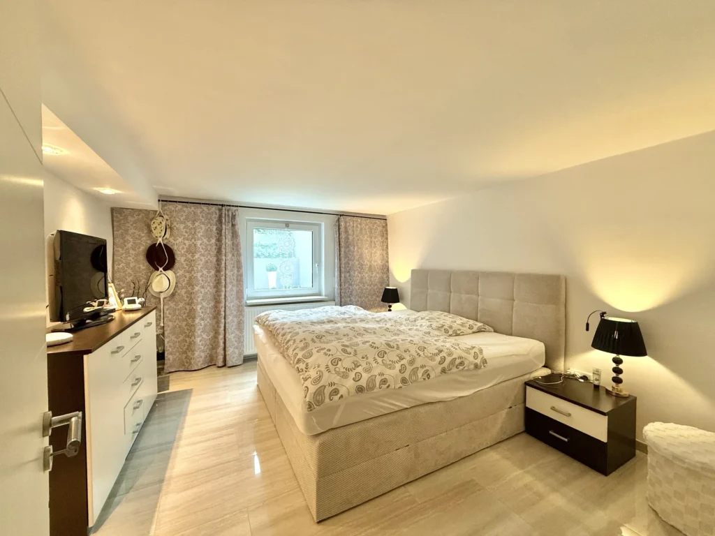 Schlafzimmer im Untergeschoss mit Doppelbett und Dachfenster